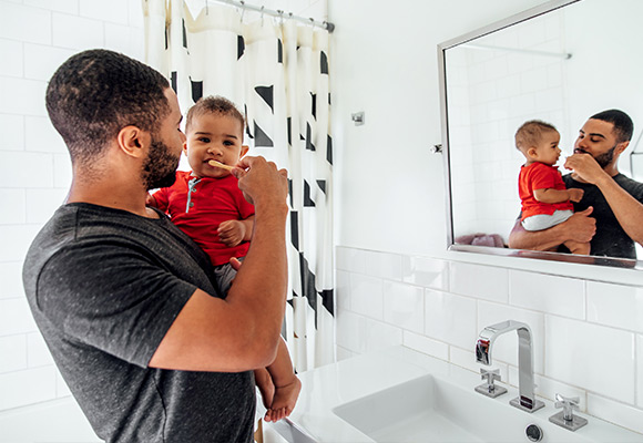 A dad brushing his sons teeth