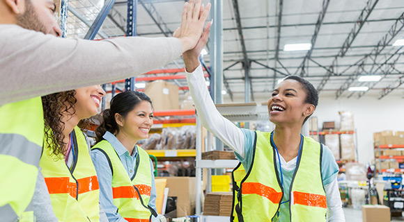 Warehouse employees high fiving