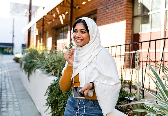 A smiling woman in a headscarf is happy with her Delta Dental insurance coverage.
