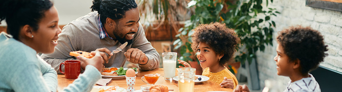 A family sitting at a table eating dinner and talking 
