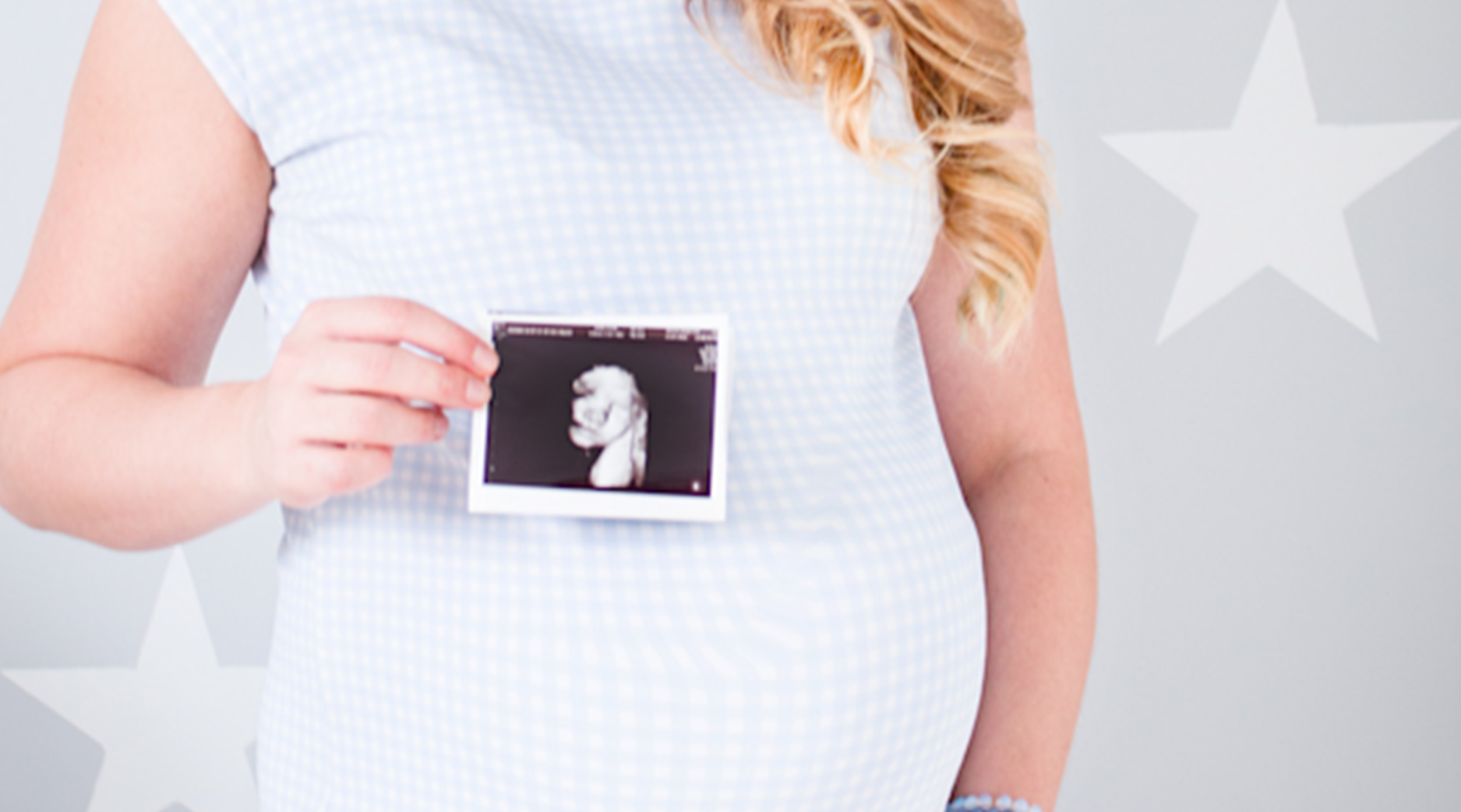 A pregnant woman holding a ultrasound image